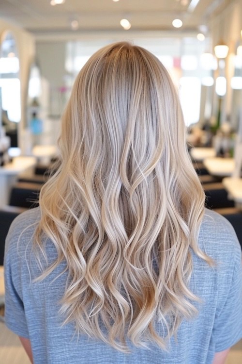 Light ash cool-toned blonde waves, shot from behind.