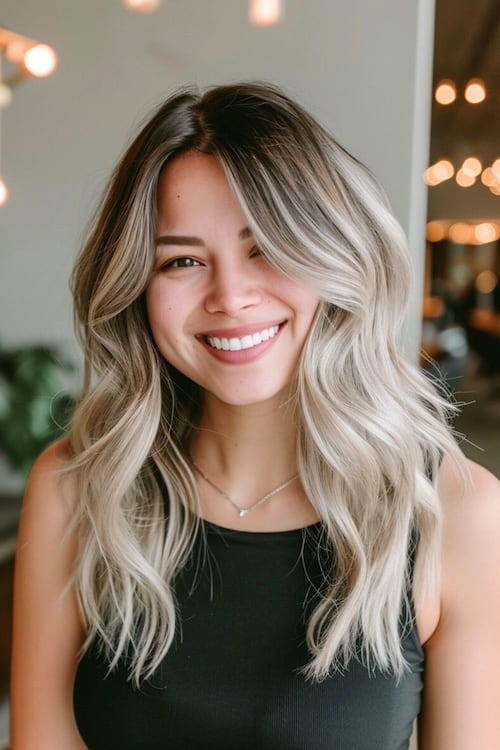 Ombre platinum blonde from dark to light on smiling woman.