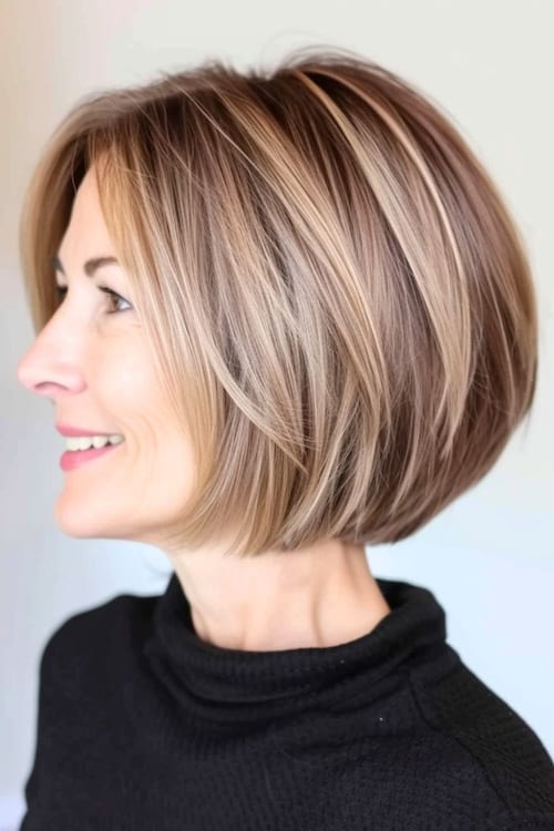 Short razored bob haircut on smiling older woman, side view.