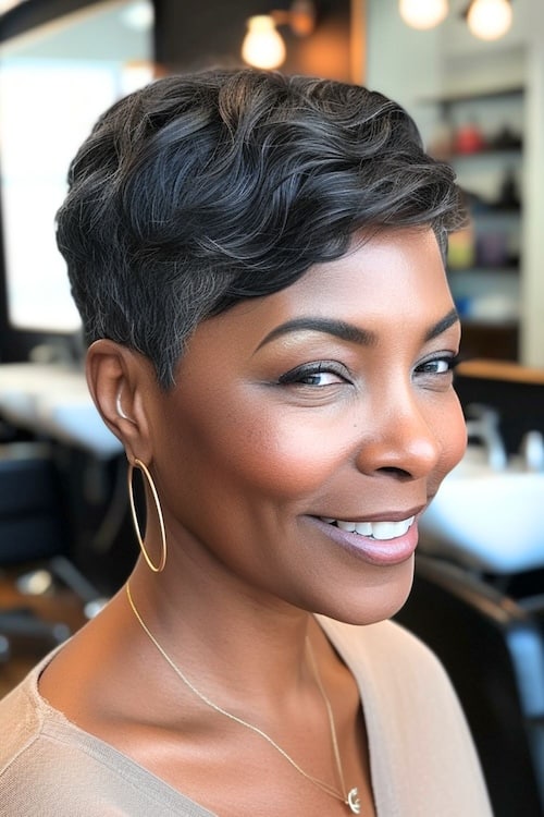 Wavy pixie cut with tapered sides on older black woman in hair salon.