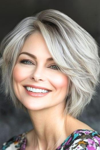 Choppy Bob with Root Volume Hairstyle on a smiling woman with silver hair.