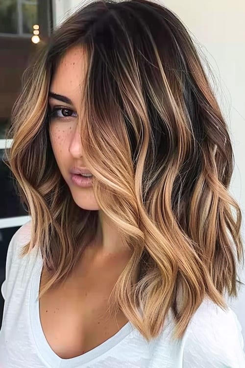 Dark brown hair with honey blonde balayage highlights.