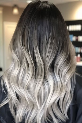 Dark To Ash Platinum Ombre Hairstyle on a woman with ombre dark to blonde hair in hair salon, back view.