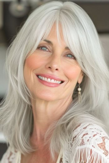 Medium Silver Layers With Bangs Hairstyle on smiling older woman with gray hair.