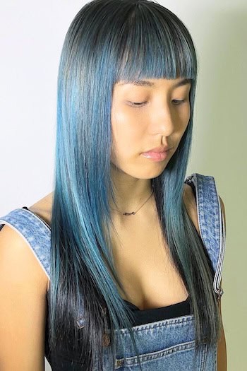 Straight Long Teal Hair With Blunt Bangs Hairstyle on a smiling woman with long teal hair.