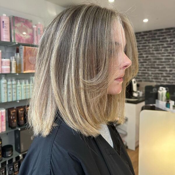 a woman inside a salon wearing a black cape