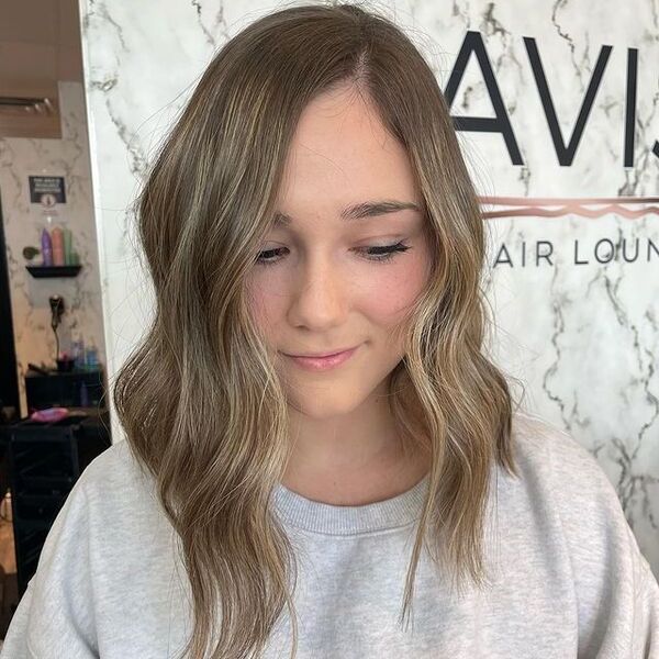 a woman inside a salon wearing a gray longsleeve