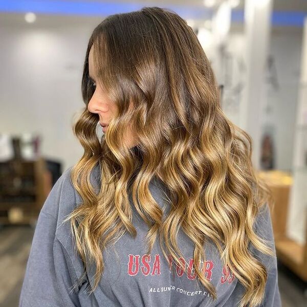 a woman inside a salon wearing a gray printed shirt