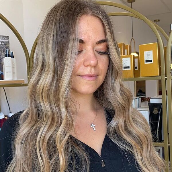 a woman inside a salon wearing a necklace and dark blue blouse