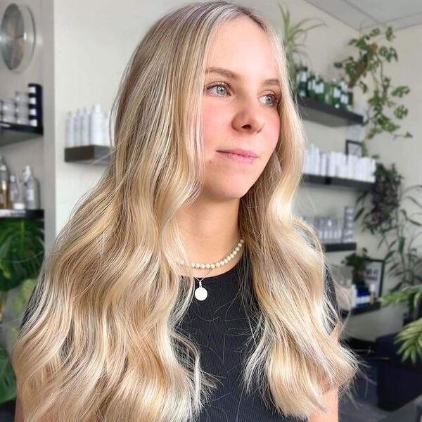 a woman inside a salon wearing a pearl necklace and black shirt