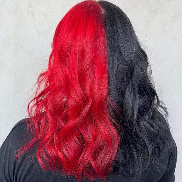 A woman showing her half red and half black hair while wearing her black shirt