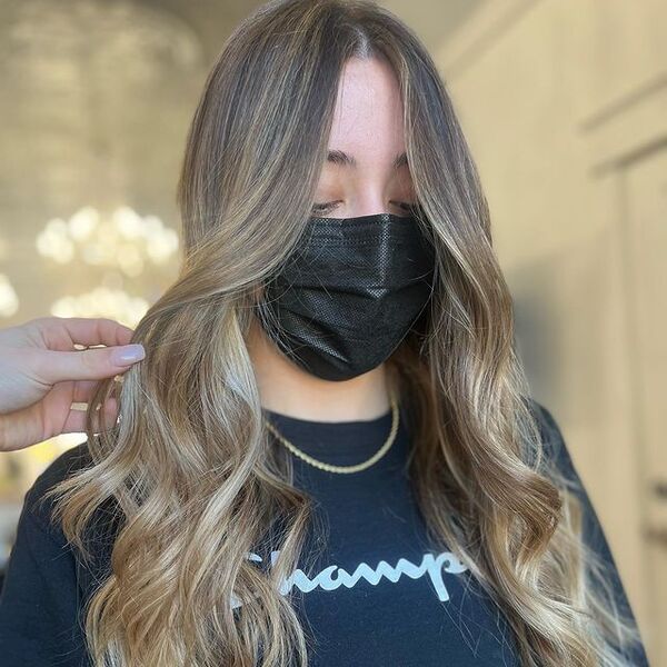 a woman with black facemask and necklace wearing a printed champions longsleeve