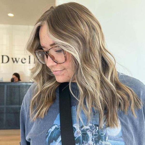 a woman with eyeglasses wearing a gray printed shirt