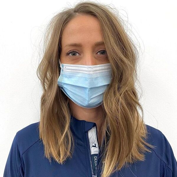 a woman with surgical facemask wearing a blue jacket