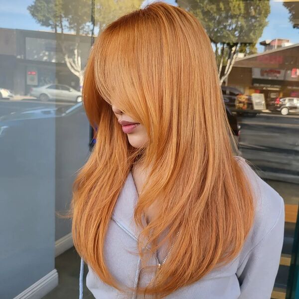 Copper Strawberry Blonde Hair - a woman wearing a gray jacket