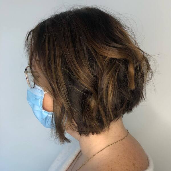 Dark-coated Bob Haircut - a woman wearing mask and gold necklace.