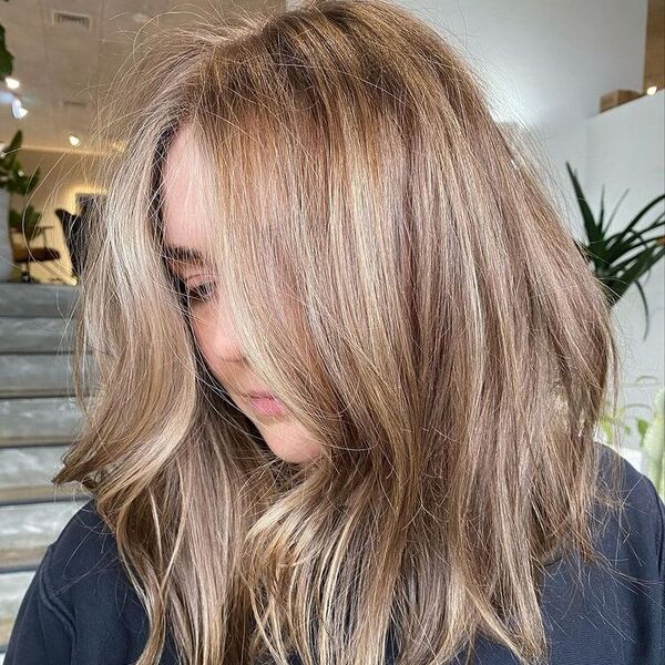 Full Head with Lowlights Brown Hair - a woman at the stair and is wearing a black t shirt