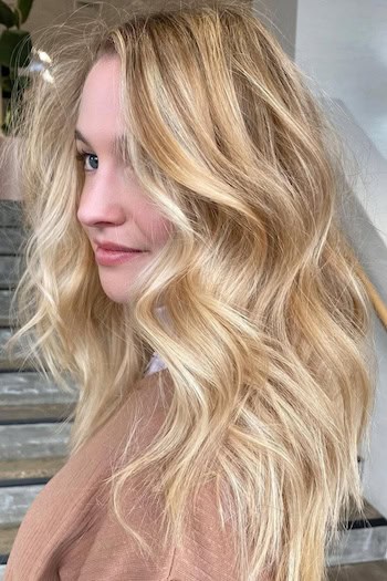 Golden Blonde Tousled Waves on a woman with blonde wavy hair, side view.