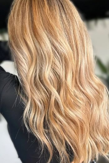 Golden Blonde Waves With Highlights on a woman with blonde hair, back view.