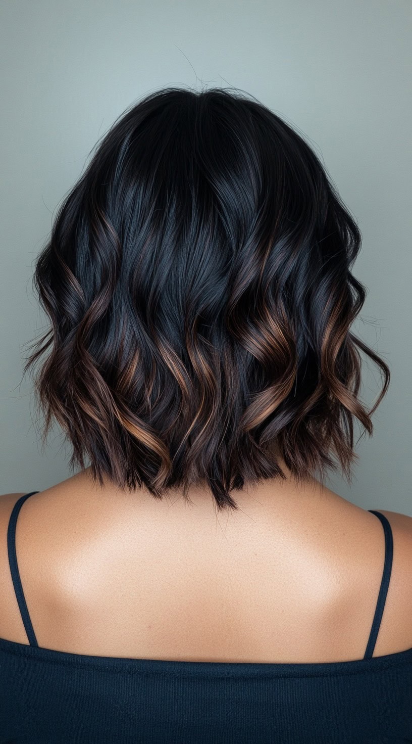 In this photo, a textured lob is enhanced by rich caramel balayage highlights scattered throughout the waves.