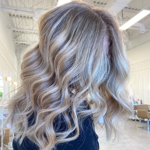 Light Blonde Balayage - a woman in a salon wearing a black shirt