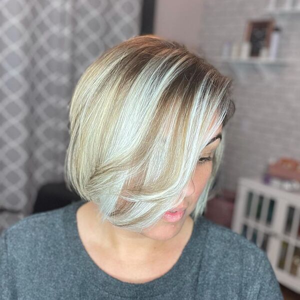 Light Brown Base with Platinum Balayage - a woman in a salon wearing a dark gray shirt