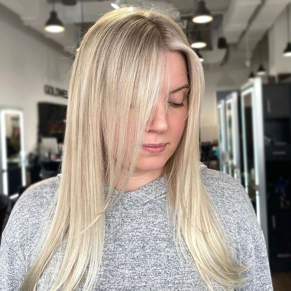 Low Maintenance Blonde Balayage - a woman wearing a gray sweater with hood