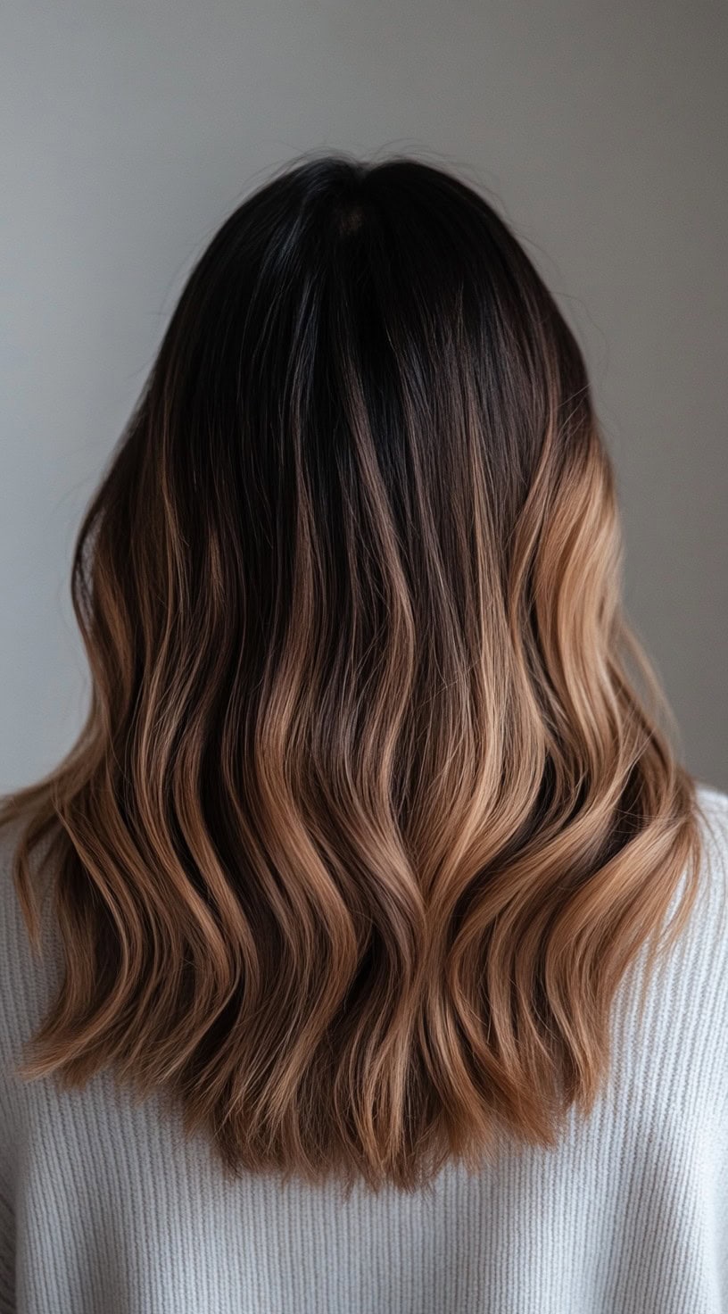 Medium-length hair with dark roots fading into caramel blonde balayage.