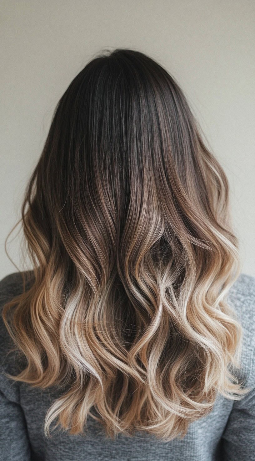 Medium-length, wavy brunette hair with bright blonde balayage at the ends.