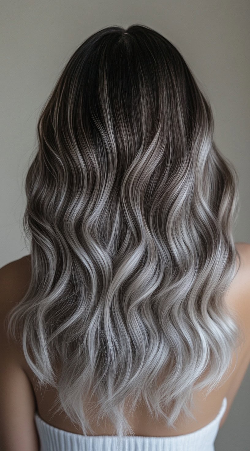 Medium-length wavy hair with dark roots and platinum blonde balayage highlights.