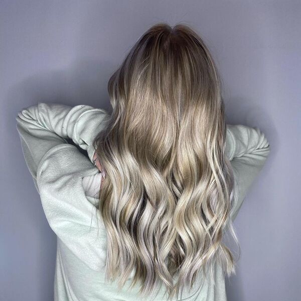 Pearly Blonde Balayage - a woman wearing a pastel green sweater