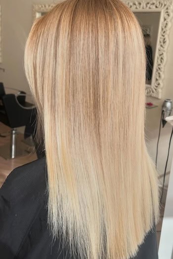 Straight Warm Blonde Hair on a woman with long blonde hair, back view.