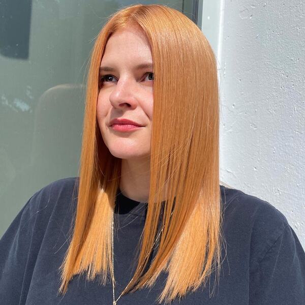 Strawberry Blonde for Straight Hair - a woman wearing a black shirt