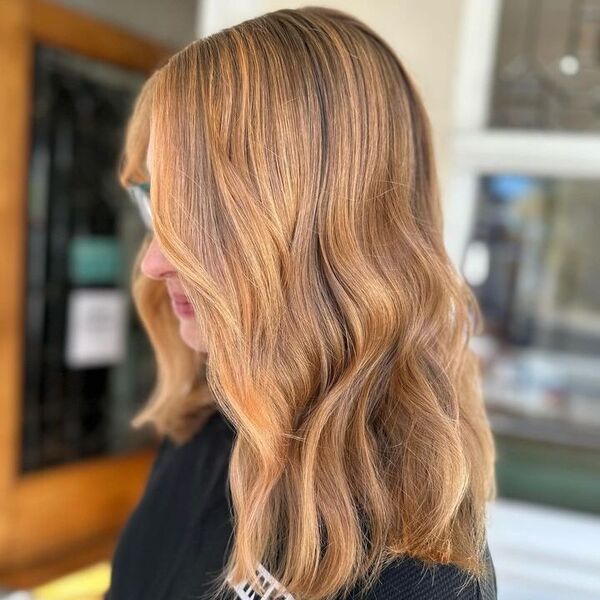 Strawberry Blonde Highlights for Dark Hair - a woman wearing a black shirt