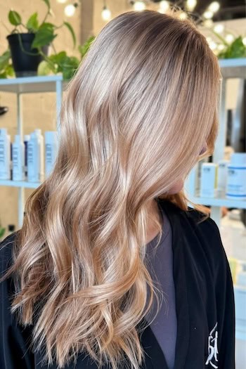 Subtle Strawberry Blonde Waves on a woman with blonde hair, side view.