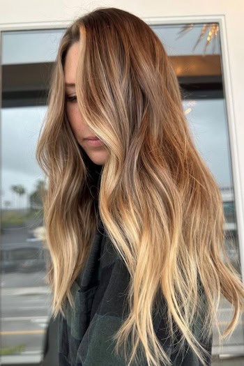 Warm Beach Blonde Hair on a woman with very long blonde and brown hair, side view.