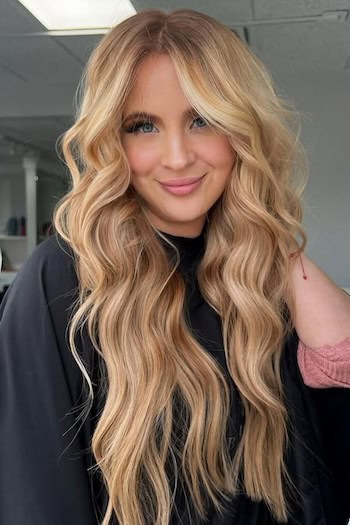 Warm Blonde Hair Extensions on a smiling woman with long blonde hair.