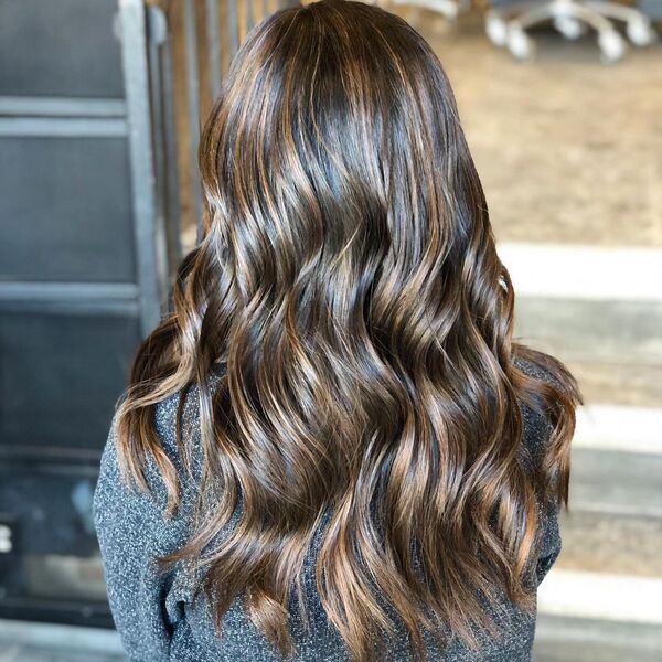 Warm Brown Balayage - a woman wearing a dark gray sweater