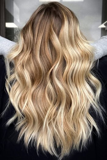 Warm Honey Blonde Blended Waves on a woman with long blonde hair, back view.